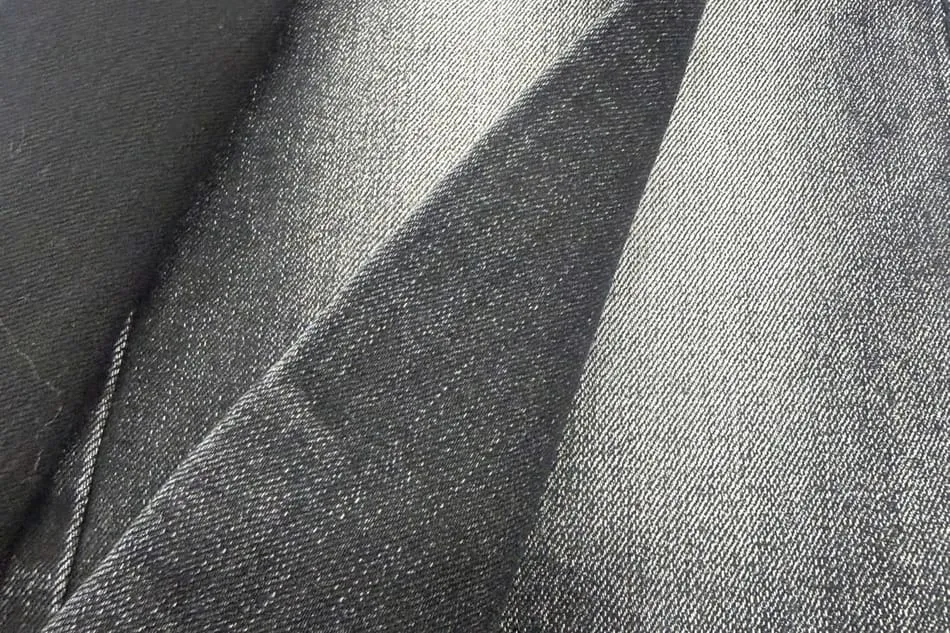 Vải denim màu đen, nhìn gần thấy rõ những đường gân chéo chạy nghiêng đặc trưng