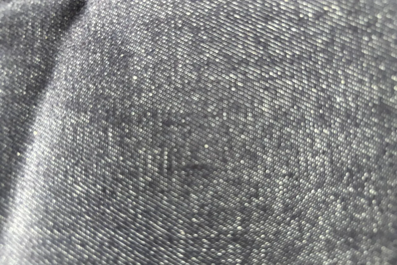 Vải denim màu xám đen, nhìn gần thấy rõ những đường gân chéo chạy nghiêng đặc trưng