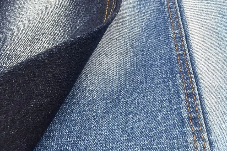 Mặt vải denim với những vệt bạc trắng chạy dọc, nổi rõ trên nền xanh chàm đậm